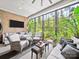 A sunroom filled with natural light showcases brick walls and comfortable wicker furniture at 217 Turtleback Rdg, Weddington, NC 28104