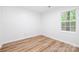 Bright bedroom with a window providing natural light, complemented by modern, wood-look flooring at 3100 Hickory Grove Dr, Monroe, NC 28110