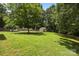 A lush backyard with mature trees and an outbuilding is set on a private lot at 324 Swamp Fox Dr, Fort Mill, SC 29715