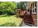 Backyard featuring a large wooden deck with an awning and stairs leading to the grassy area at 324 Swamp Fox Dr, Fort Mill, SC 29715