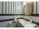 Bathroom with a modern gray vanity, striped wallpaper, a large framed mirror and a white sink at 324 Swamp Fox Dr, Fort Mill, SC 29715