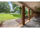 Covered front porch featuring brick columns, stone flooring and a view of the front yard and street at 324 Swamp Fox Dr, Fort Mill, SC 29715
