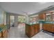 Bright kitchen with green countertops, light wood cabinets, central island, and a view to the sunroom at 324 Swamp Fox Dr, Fort Mill, SC 29715