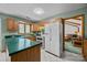 Functional kitchen with green countertops, light wood cabinets, white appliances, and a view to the living room at 324 Swamp Fox Dr, Fort Mill, SC 29715