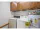 Laundry room featuring a washer, a dryer, a water heater, and cabinets for storing laundry supplies at 324 Swamp Fox Dr, Fort Mill, SC 29715