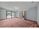 Spacious living room featuring neutral walls, plush carpeting and a sliding door to the outside at 324 Swamp Fox Dr, Fort Mill, SC 29715