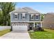 Charming two-story home with stone accents, well-manicured lawn, and an attached two-car garage at 3734 Stanley Creek Dr, Mount Holly, NC 28120