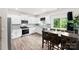 Bright kitchen features stainless steel appliances, white cabinets, granite counters, and a wooden dining table at 3734 Stanley Creek Dr, Mount Holly, NC 28120