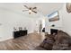 Bright living room with a fireplace, hardwood flooring, and a ceiling fan, creating a cozy atmosphere at 3734 Stanley Creek Dr, Mount Holly, NC 28120