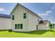 Back exterior featuring vinyl siding, well-maintained lawn, and solar panels on a neighboring home at 3855 Tersk Dr, Midland, NC 28107