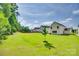 Spacious, grassy backyard featuring a young tree and glimpses of neighboring homes, offering ample space at 3855 Tersk Dr, Midland, NC 28107