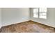 Well-lit bedroom showcasing wood-look flooring and a large window offering neighborhood views at 3855 Tersk Dr, Midland, NC 28107