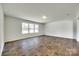 Bright, open living space with modern flooring and three large windows at 3855 Tersk Dr, Midland, NC 28107