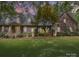 Charming brick home featuring a well-manicured lawn and inviting front porch, set beneath a colorful dusk sky at 394 E Goldmine Rd, Wadesboro, NC 28170