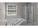 Bright bathroom featuring a soaking tub, glass shower, and large window at 4519 Rock Stream Dr, Charlotte, NC 28269