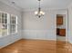 Inviting dining room with hardwood floors, wainscoting, and a chandelier adjacent to a glimpse of the kitchen at 4519 Rock Stream Dr, Charlotte, NC 28269