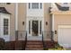 View of front porch with brick steps, decorative iron railings, and sidelights framing the front door at 4519 Rock Stream Dr, Charlotte, NC 28269