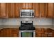 Close-up of a well-maintained kitchen featuring a range, microwave, and wooden cabinets and granite countertops at 4519 Rock Stream Dr, Charlotte, NC 28269