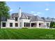 Expansive backyard featuring a patio, in-ground pool, well-manicured lawn, and a luxurious white brick home at 4714 Ockley Manor Ln, Charlotte, NC 28226