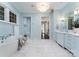 A luxurious bathroom with a standalone tub, marble floors, and elegant blue cabinetry at 4714 Ockley Manor Ln, Charlotte, NC 28226