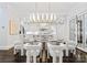 Elegant dining area with a glass table, modern lighting, and views into the gourmet kitchen at 4714 Ockley Manor Ln, Charlotte, NC 28226