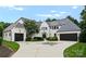 Impressive exterior featuring a circular driveway, lush landscaping, and a three-car garage at 4714 Ockley Manor Ln, Charlotte, NC 28226