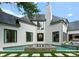 Luxurious home exterior with a pool, pristine white brick, modern black windows, and a well-manicured lawn at 4714 Ockley Manor Ln, Charlotte, NC 28226