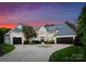 Beautiful exterior of a home with a circular driveway, two-car garage, and professionally landscaped yard at 4714 Ockley Manor Ln, Charlotte, NC 28226