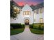 The front entry of this home features a round front door, lush landscaping and manicured lawn at 4714 Ockley Manor Ln, Charlotte, NC 28226