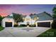 Stunning white brick home with a circular driveway, two-car garage, and manicured landscaping at 4714 Ockley Manor Ln, Charlotte, NC 28226