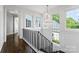 Staircase featuring dark wood floors, white trim, iron balusters, chandelier, and multiple windows at 4714 Ockley Manor Ln, Charlotte, NC 28226