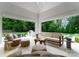 Covered patio with an outdoor seating area and views of the manicured backyard and lush trees at 4714 Ockley Manor Ln, Charlotte, NC 28226