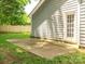 View of the level back yard and side of home with concrete patio and door at 5019 Poplar Glen Dr, Matthews, NC 28104