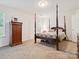 Serene bedroom featuring a four-poster bed, natural light, and comfortable carpeting at 5019 Poplar Glen Dr, Matthews, NC 28104