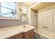 Outdated bathroom with a single vanity, mirror, and tub with white tile surround at 537 N Main St, Mooresville, NC 28115
