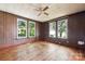 Bedroom with wood paneled walls, wood floor and three windows with exterior views at 537 N Main St, Mooresville, NC 28115