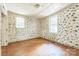 Bedroom with white and gold wallpaper, wood floor and a double hung window at 537 N Main St, Mooresville, NC 28115