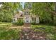 Two-story home with white siding, front-facing steps, and mature trees offering plenty of shade at 537 N Main St, Mooresville, NC 28115