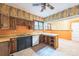 Outdated kitchen with wood cabinets, black dishwasher, and an island in need of repair at 537 N Main St, Mooresville, NC 28115