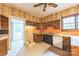 View of a kitchen needing repairs with wood cabinets, tile floor and black dishwasher at 537 N Main St, Mooresville, NC 28115