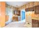 View of a fixer upper kitchen with wood cabinets, tile flooring and an open doorway at 537 N Main St, Mooresville, NC 28115
