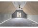 Large attic space offers carpeting, neutral tones, and a dormer window at 6017 Millbury Ct, Charlotte, NC 28211