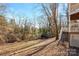 Sloping backyard featuring a wooded area with stairs leading up to a deck, offering a private retreat at 6017 Millbury Ct, Charlotte, NC 28211