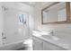 Bright bathroom with tiled shower, vanity with framed mirror, and a window at 6017 Millbury Ct, Charlotte, NC 28211