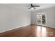 Cozy bedroom featuring hardwood floors, a ceiling fan and large window at 6017 Millbury Ct, Charlotte, NC 28211