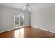 Bright bedroom boasts hardwood floors, a ceiling fan, and large window at 6017 Millbury Ct, Charlotte, NC 28211