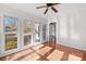 A bright bedroom features hardwood floors, ceiling fan and multiple windows at 6017 Millbury Ct, Charlotte, NC 28211