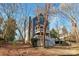 Charming gray two-story home with a double-decker porch and brick chimney, nestled among trees at 6017 Millbury Ct, Charlotte, NC 28211