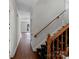 Hallway with hardwood floors and view of staircase with decorative runner at 6017 Millbury Ct, Charlotte, NC 28211