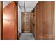 Hallway with wood paneled walls, an open doorway, and a carpeted floor at 6017 Millbury Ct, Charlotte, NC 28211